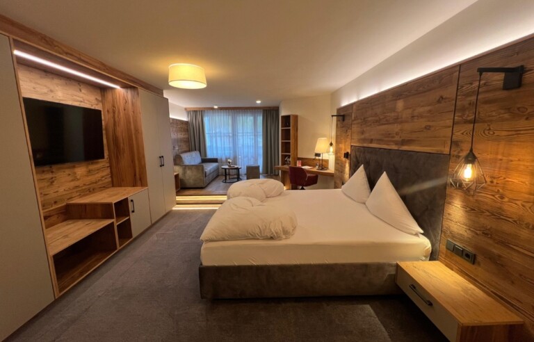 Geräumiges Doppelzimmer im Hotel ...liebes Rot-Flüh mit Holzverkleidung, TV-Bereich und modernem Lichtkonzept.