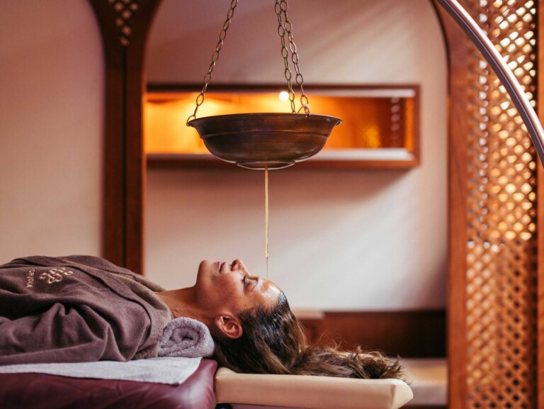 Ayurveda-Behandlung im Spa des Hotels ...liebes Rot-Flüh – Gast liegt entspannt unter hängendem Ölgefäß.