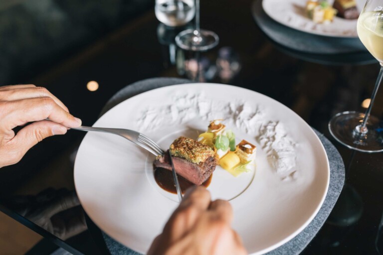 Gast genießt ein fein angerichtetes Fleischgericht im Gourmetrestaurant des Hotels ...liebes Rot-Flüh in Tirol.