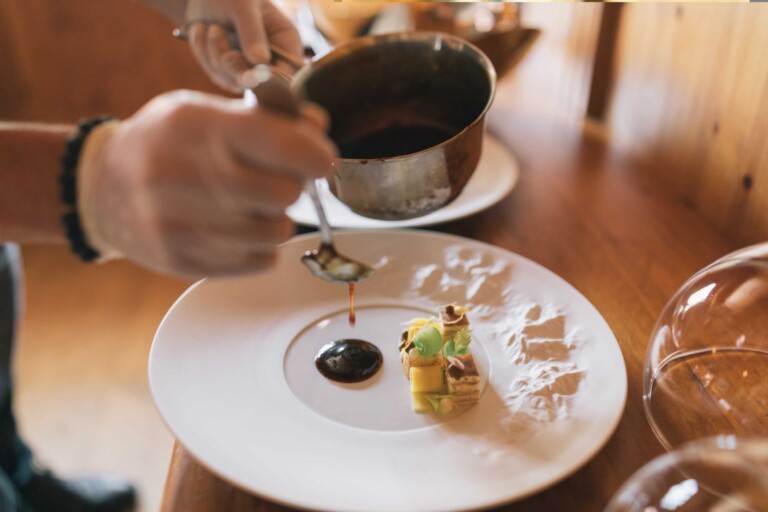 Koch vollendet Gourmetgericht mit Sauce im Gourmethotel ...liebes Rot-Flüh in Tirol.