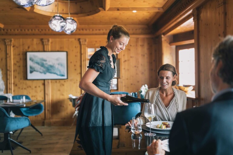 Servicemitarbeiterin serviert Gästen Menü im Gourmetrestaurant ...liebes Rot-Flüh in Tirol.