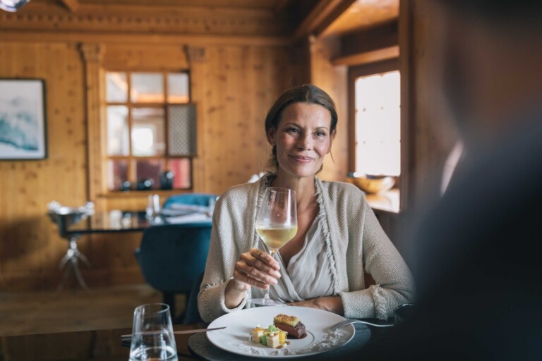 Gast genießt ein Glas Weißwein beim Abendessen im Gourmethotel ...liebes Rot-Flüh in Tirol.