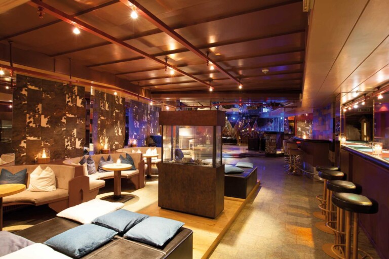 Moderne Bar im ...liebes Rot-Flüh im Tannheimer Tal mit Kamin und Hockern.