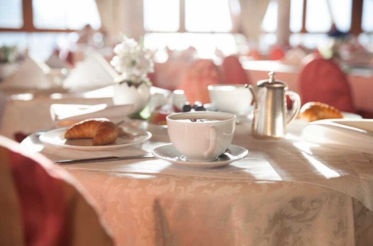 Gedeckter Frühstückstisch mit Kaffee und Croissant im ...liebes Rot-Flüh im Tannheimer Tal.