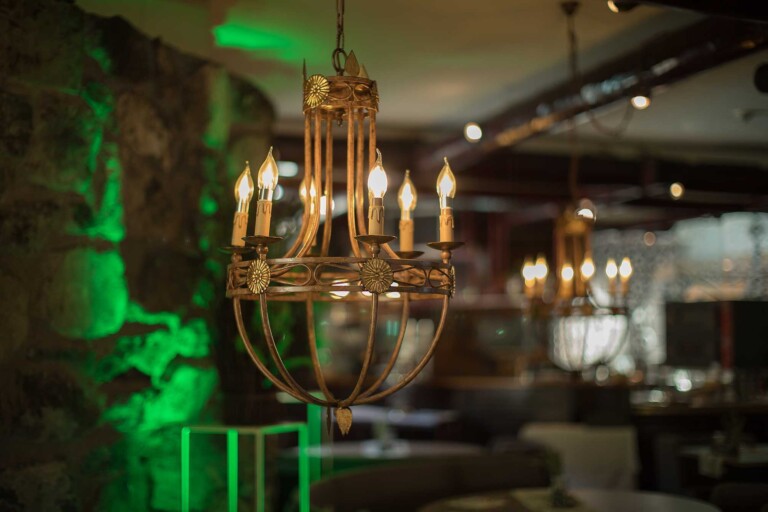 Kronleuchter in stilvollem Restaurant mit grüner Beleuchtung in Grän.