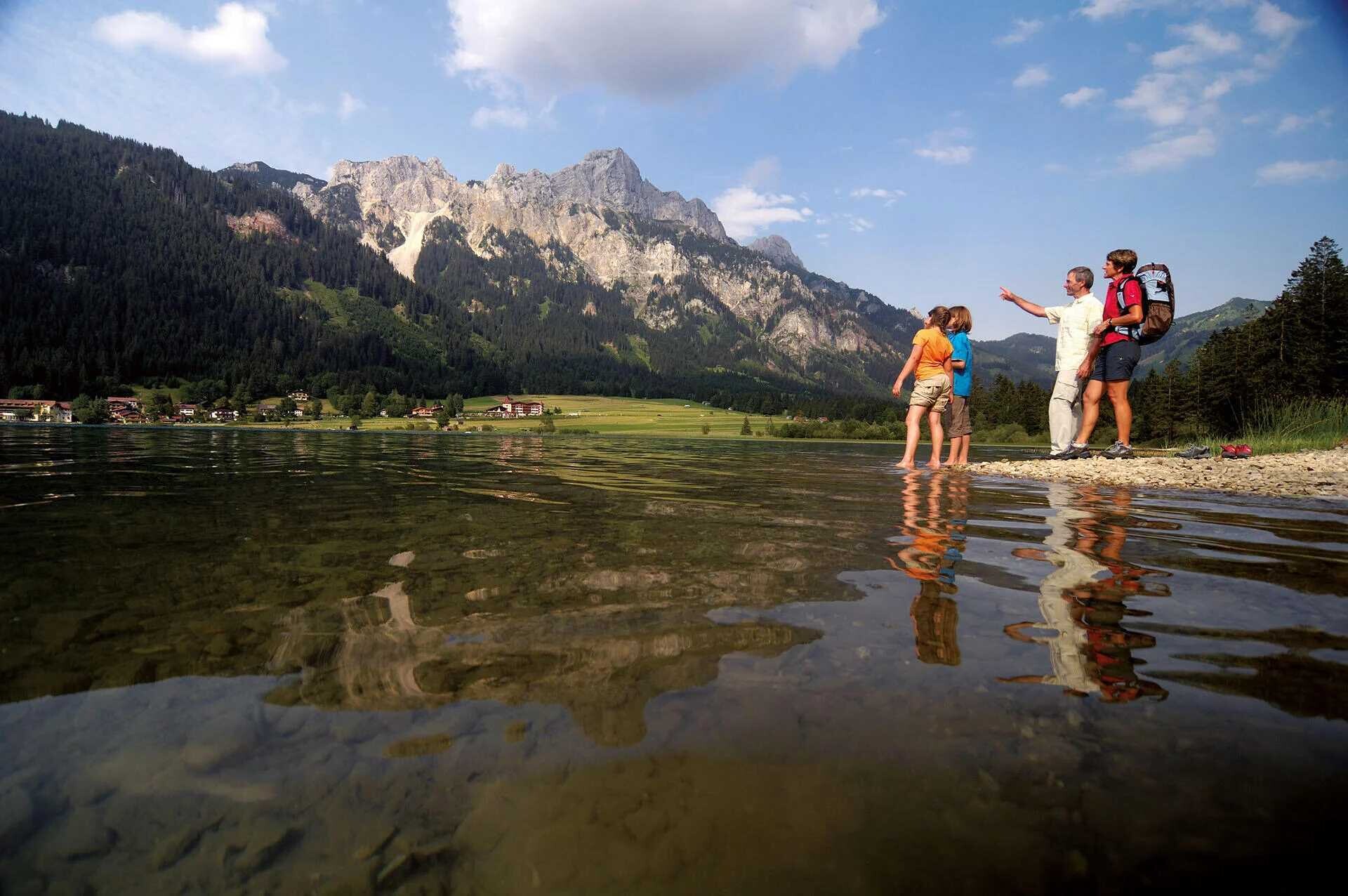 Familie auf einer Wanderung an einem See im Tannheimer Tal in der Nähe des Hotels ...liebes Rot-Flüh in Tirol.