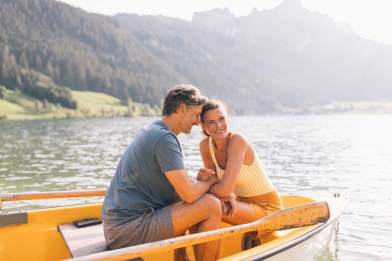 Paar in einem Ruderboot auf einem See mit Bergpanorama im Tannheimer Tal.