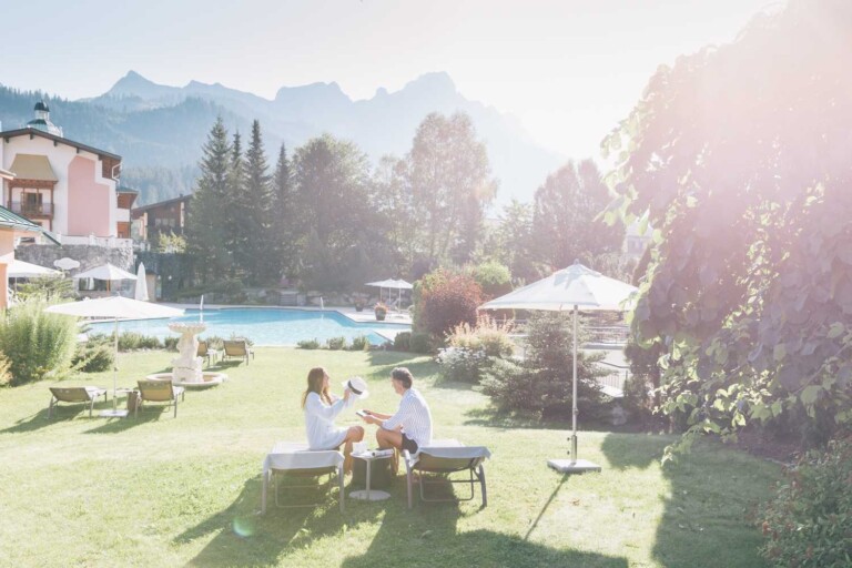 Paar relaxt auf einer Liege im Sonnenschein auf der Pool Liegewiese im ...liebes Rot-Flüh im Tannheimer Tal.
