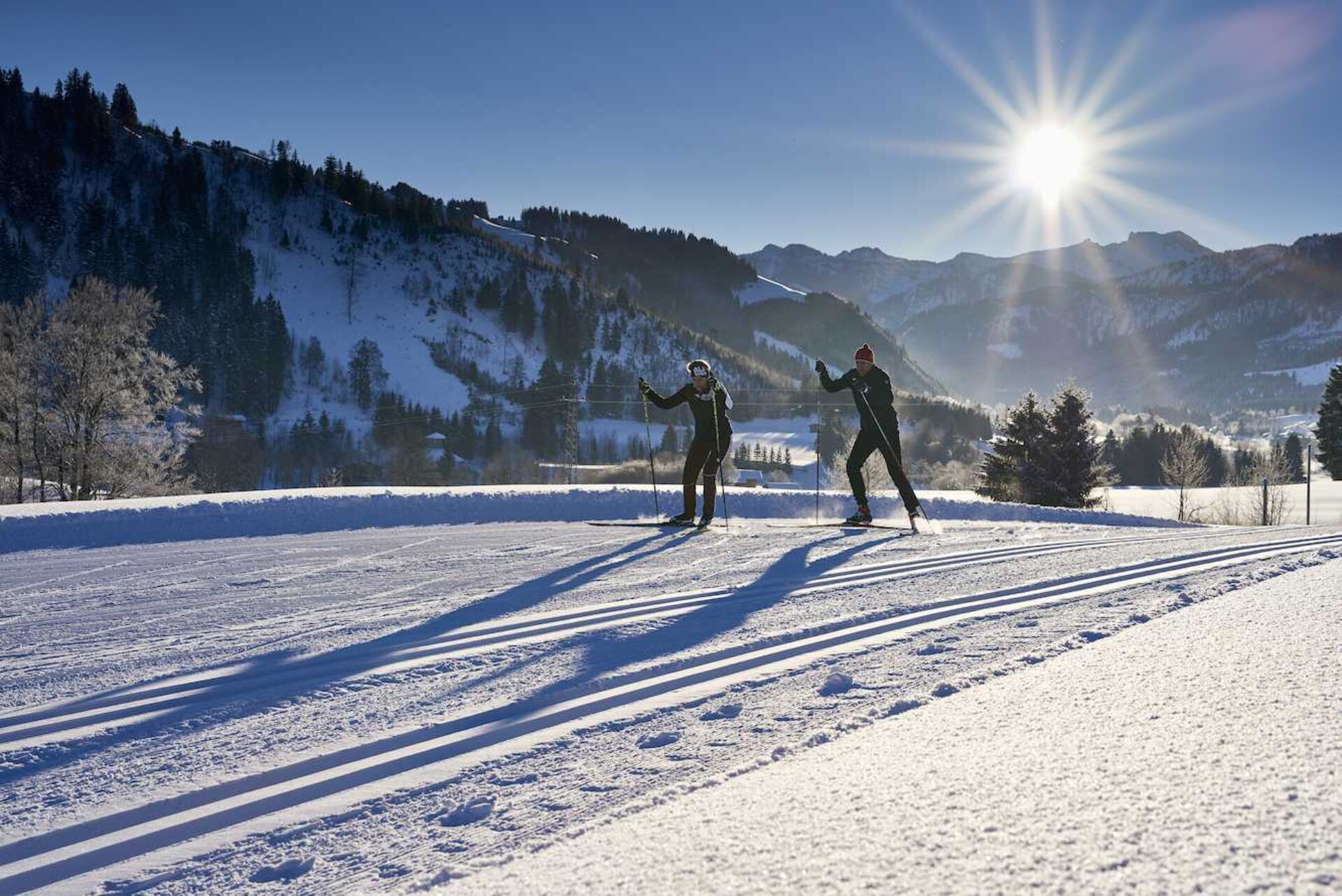 Langläufer auf Loipe im Sonnenschein im Winterurlaub im Tannheimer Tal.