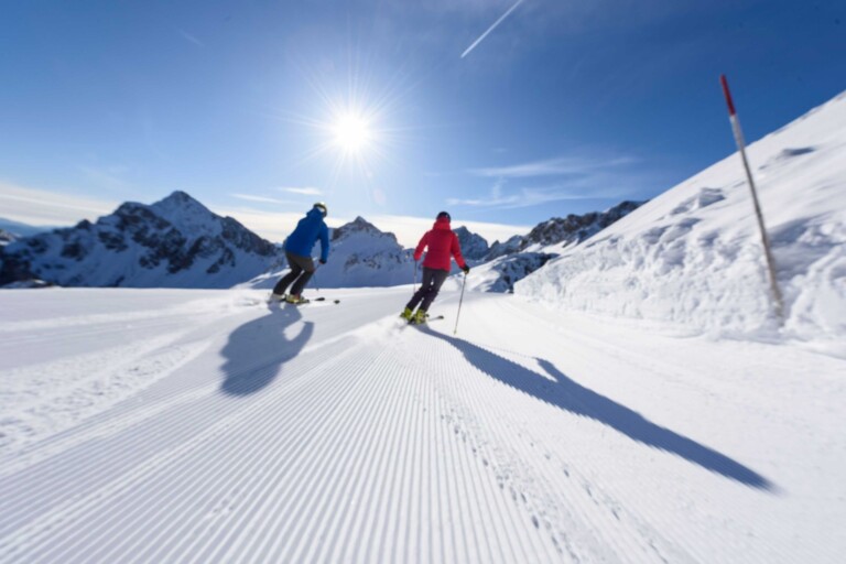 Skifahrer auf frisch gewalzter Piste im Skiurlaub im Tannheimer Tal.