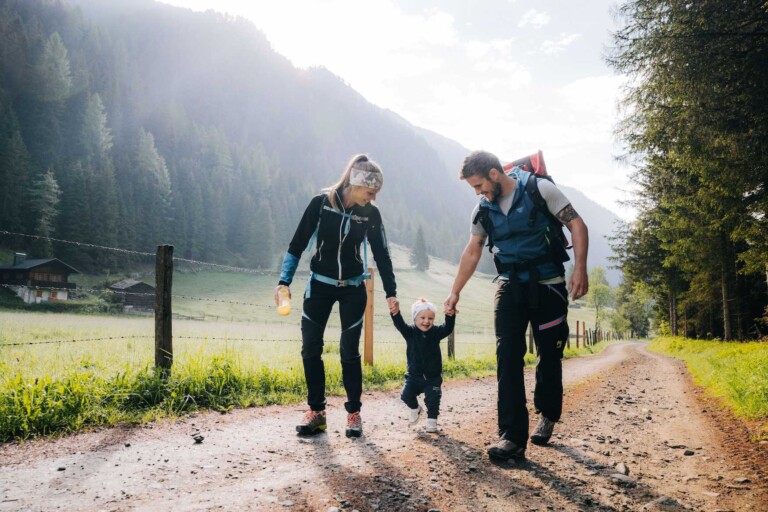 Familie mit Kleinkind beim Wandern in den der Natur mit Wald während einem Familienurlaub im Tannheimer Tal.