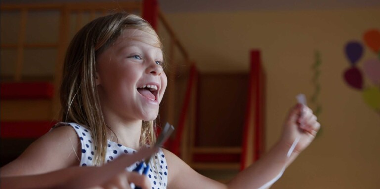 Kind bastelt ausgelassen in der Kinderbetreuung im Familienhotel im Tannheimer Tal.