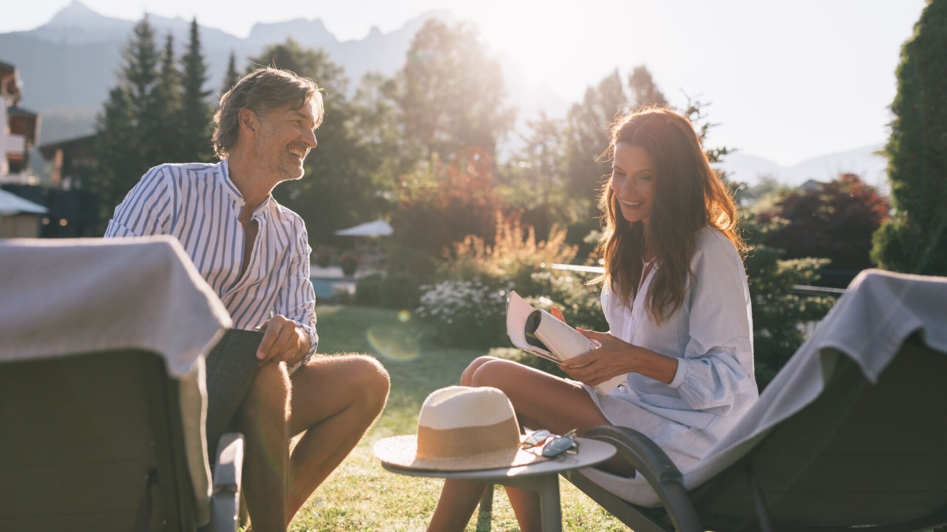Pärchen entspannt im sonnigen Hotelgarten des ...liebes Rot-Flüh im Tannheimer Tal mit Bergblick.